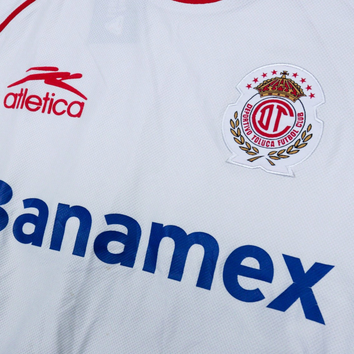 Close-up of the Atletica logo and Deportivo Toluca crest on the chest