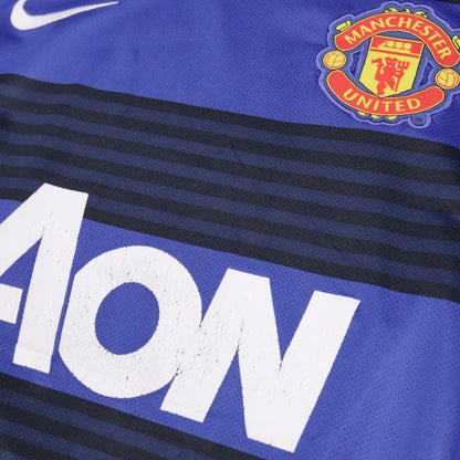 Close-up of Nike logo and Manchester United crest with cracked Aon print