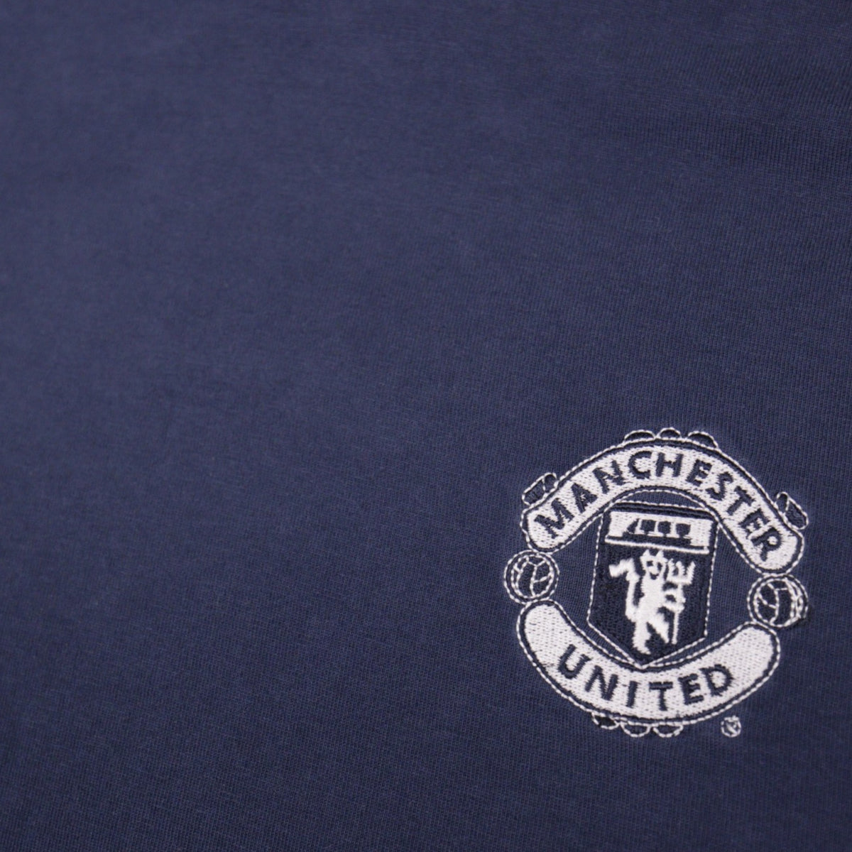 Close-up of the embroidered Manchester United crest on the chest