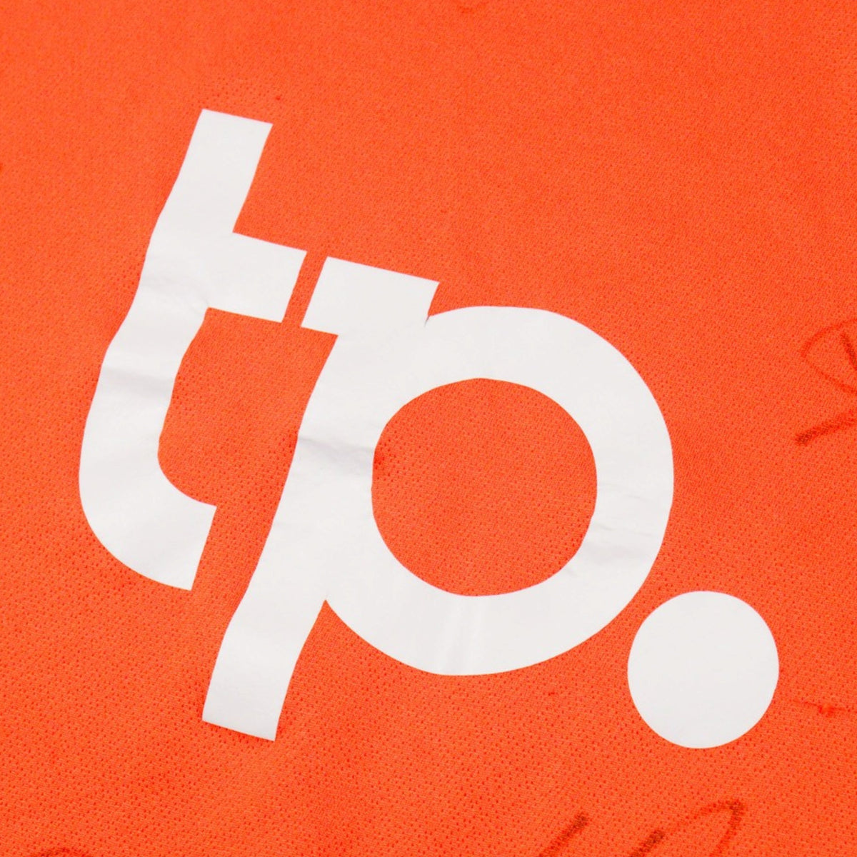 Close-up of the white tp. sponsor logo on the chest