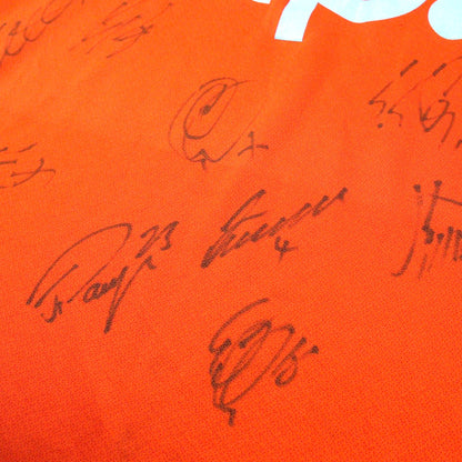 Close-up of handwritten player signatures in black ink on the shirt