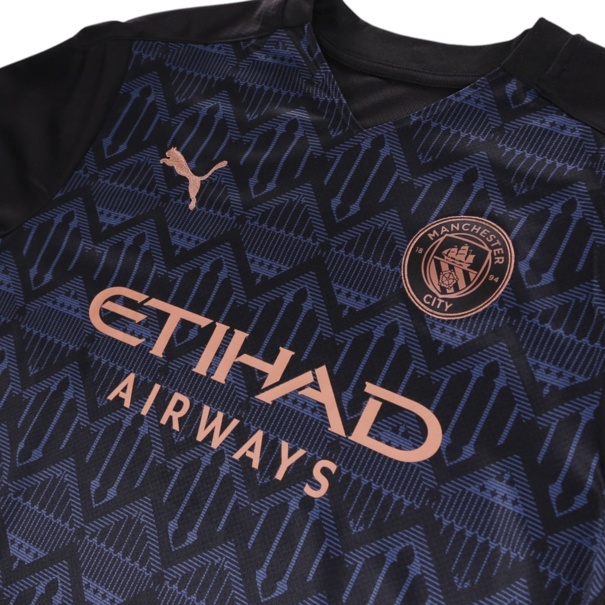 Close-up of Manchester City crest, Puma logo and Etihad Airways sponsor on chest