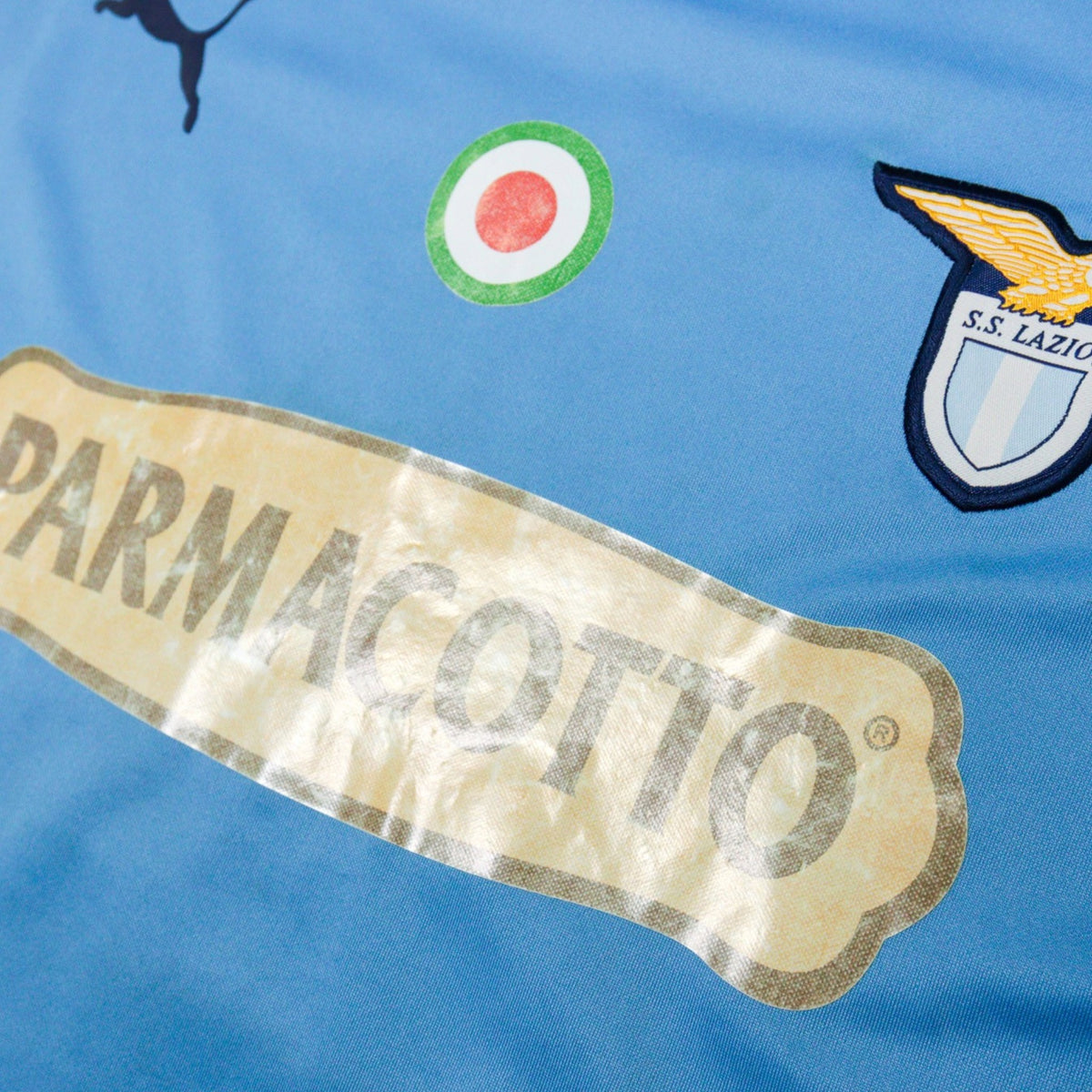 Close-up of the Parmacotto sponsor and S.S. Lazio crest on the chest