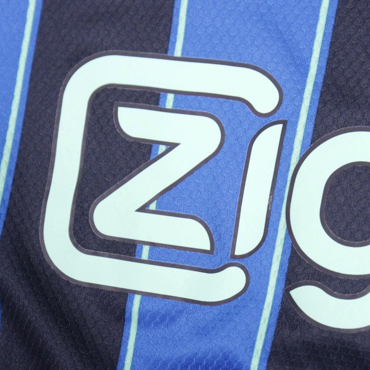 Close-up of Ziggo sponsor text on Ajax away shirt