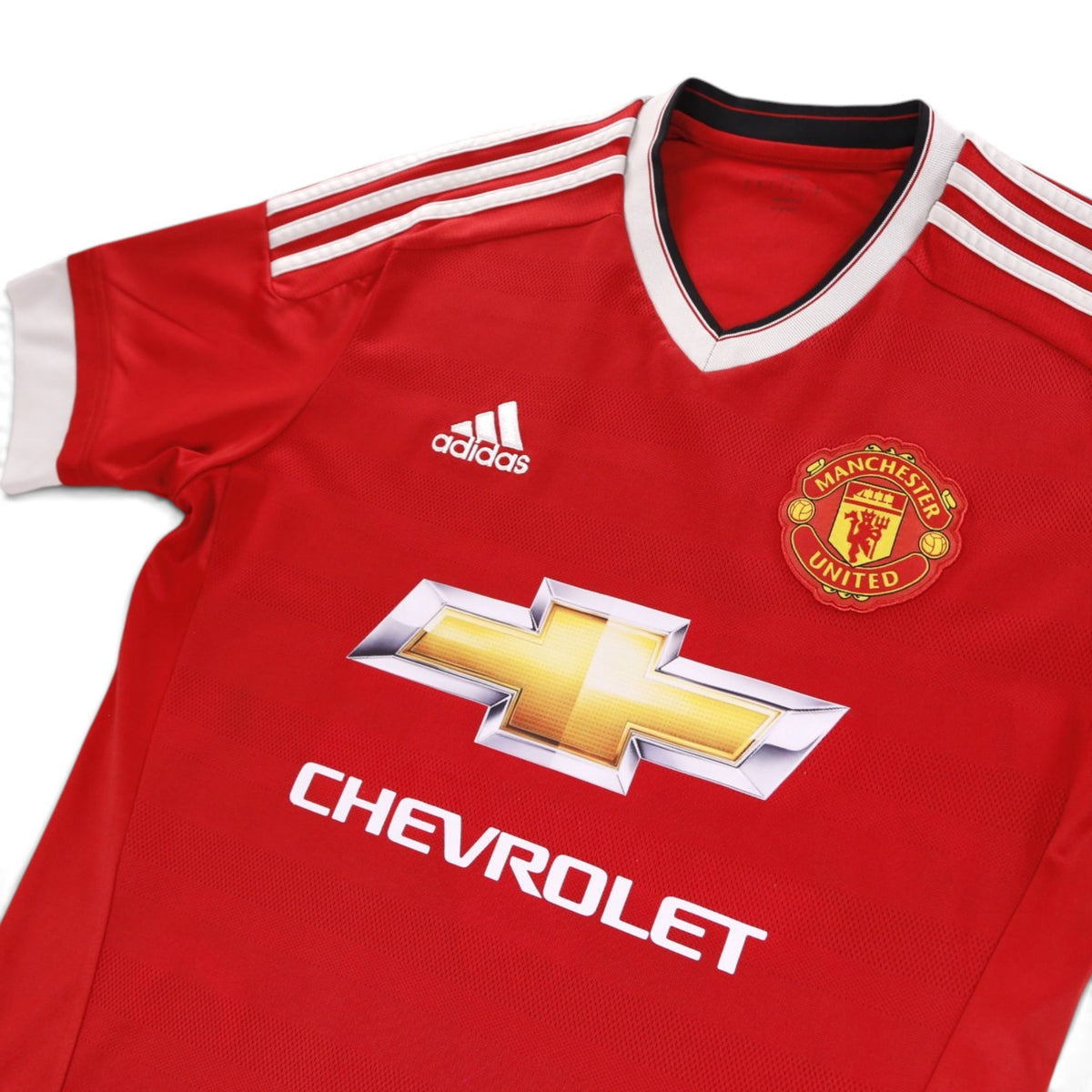 Close-up of Manchester United crest, adidas logo and Chevrolet sponsor on the chest
