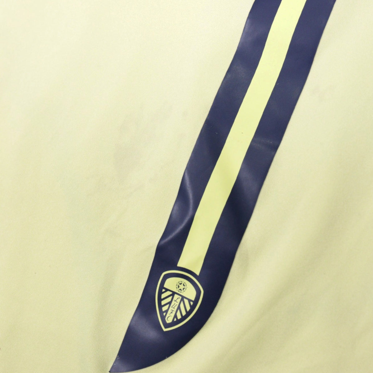 Close-up of Leeds United crest and navy stripe on away shirt