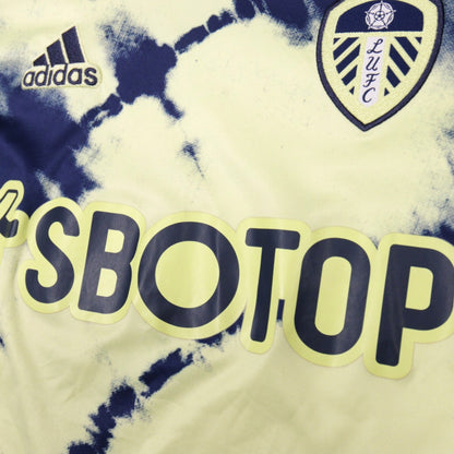 Close-up of adidas logo, Leeds United crest and SBOTOP sponsor on front