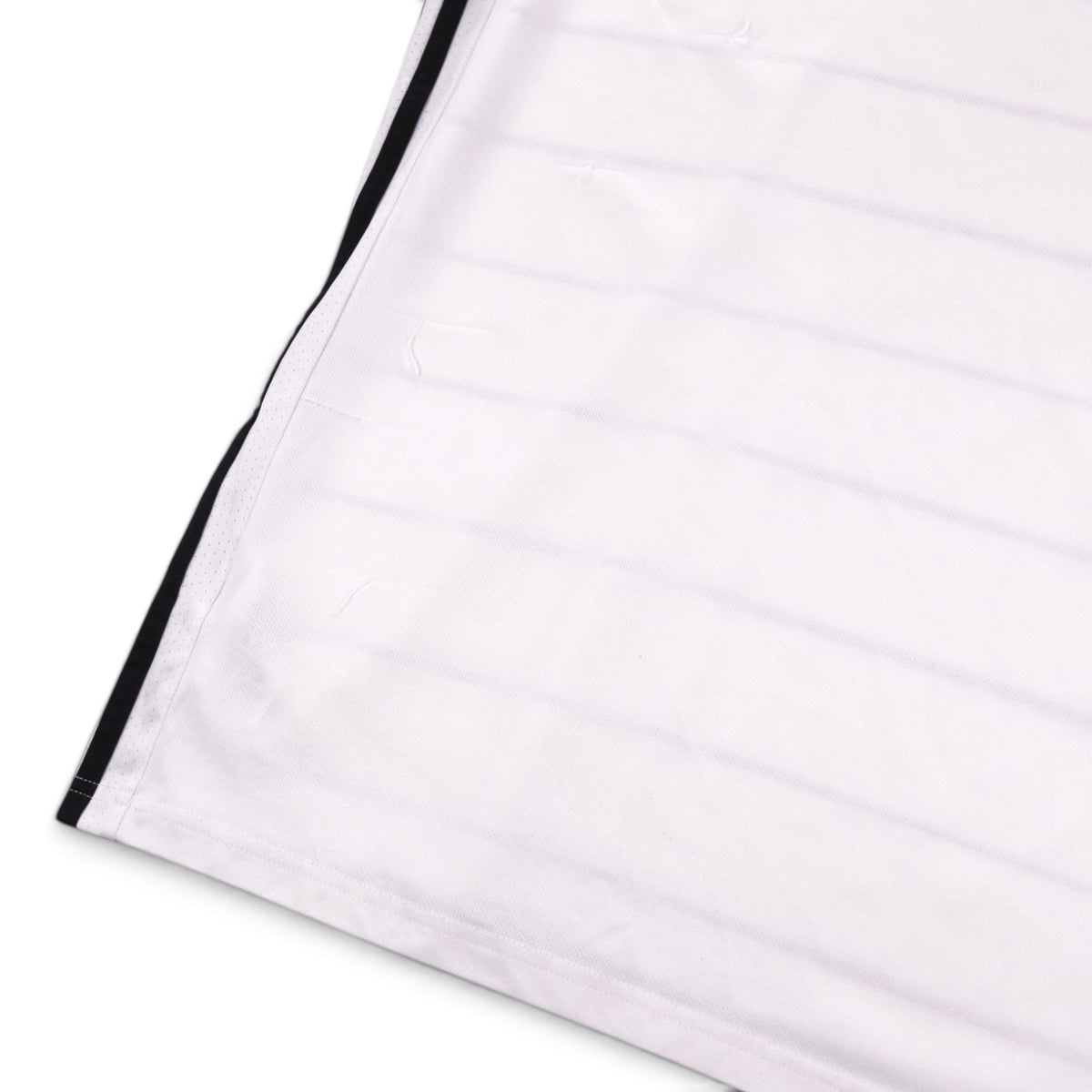 Close-up of the shirt hem and side seam showing small fabric pulls
