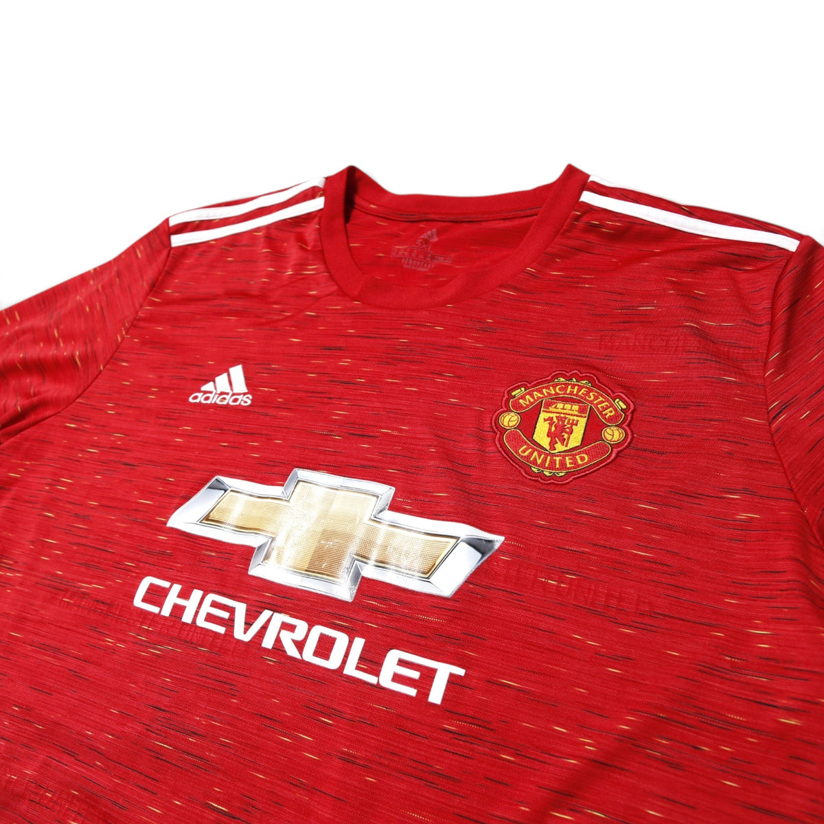 Manchester United 2020/21 home shirt front detail showing crest, adidas logo, and Chevrolet branding