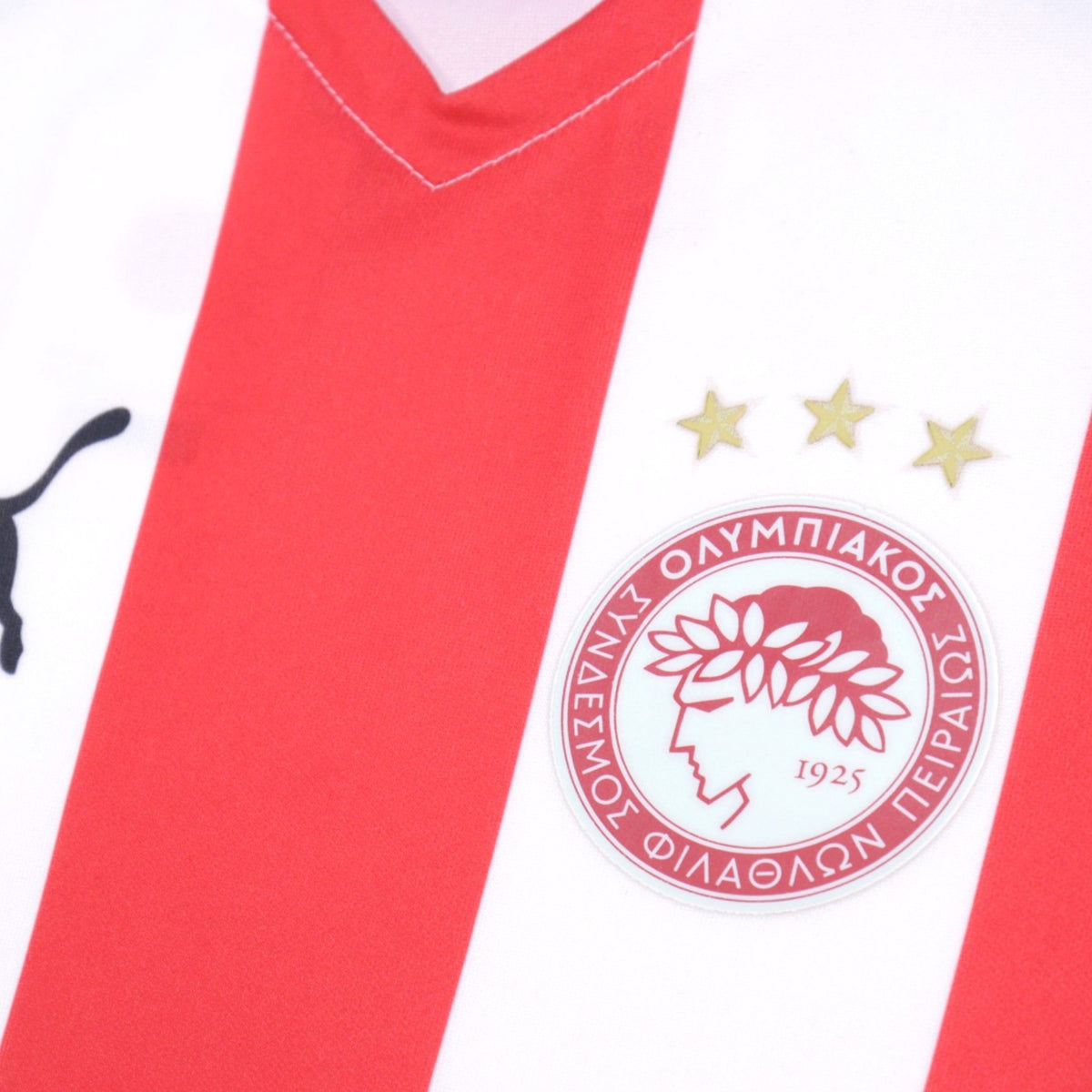 Close-up of Olympiacos crest and three stars on chest