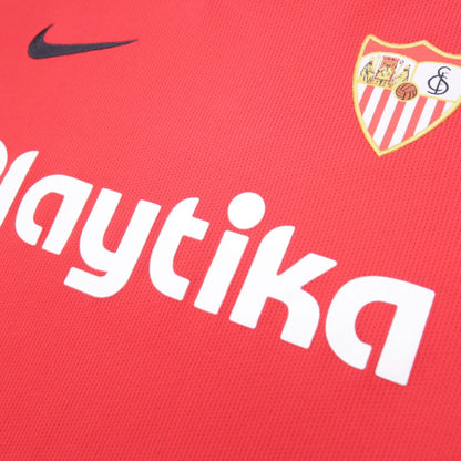 Close-up of Nike swoosh, Playtika sponsor text and Sevilla crest on the shirt front