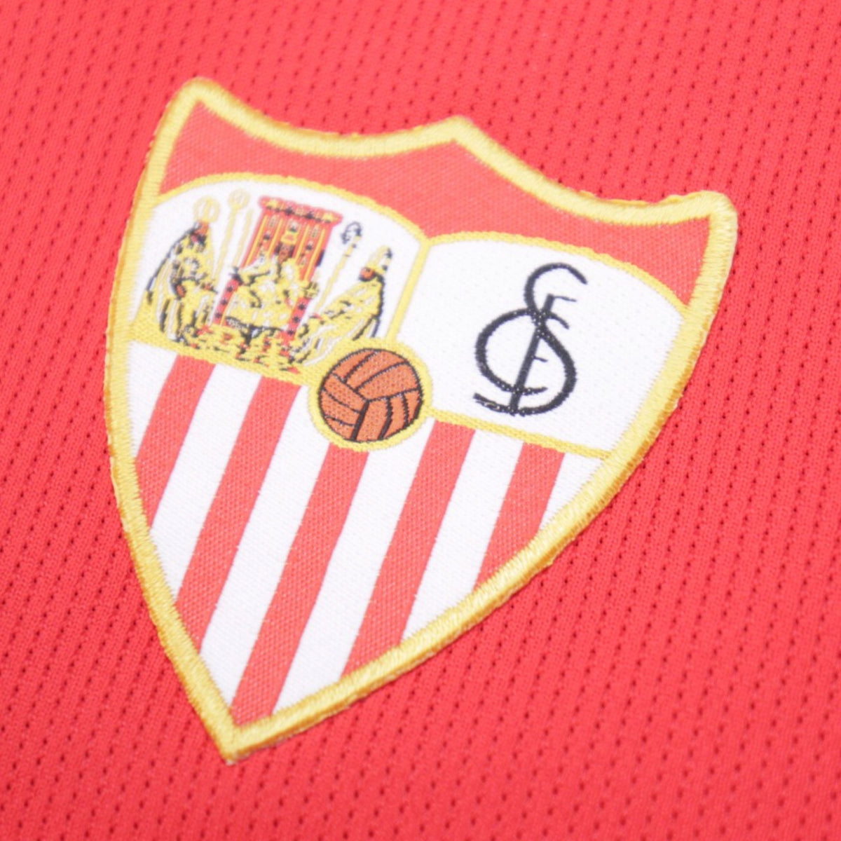 Close-up of embroidered Sevilla club crest on the shirt