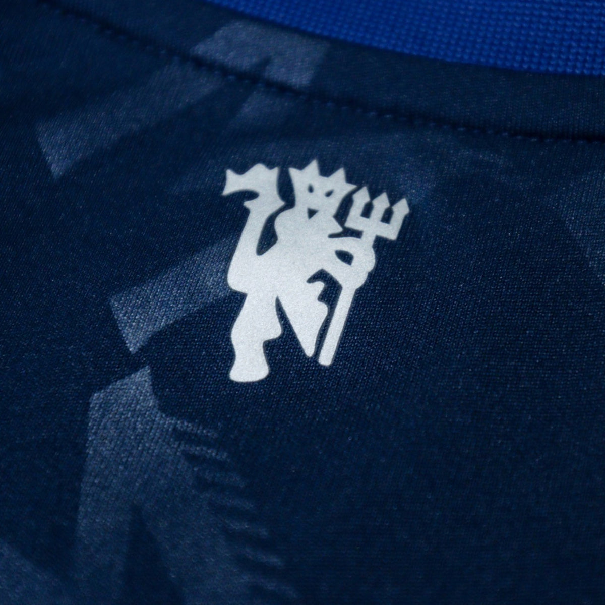Close-up of reflective devil badge on the back of the shirt