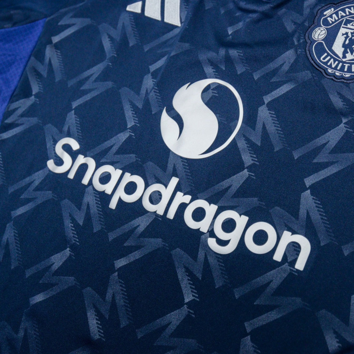 Close-up of Snapdragon sponsor and Manchester United crest on the chest