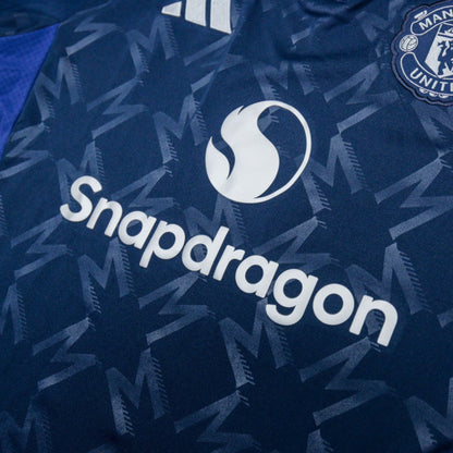 Close-up of Snapdragon sponsor and Manchester United crest on the chest