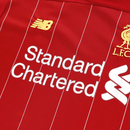 Close-up of the New Balance logo, Standard Chartered sponsor and LFC crest on the chest
