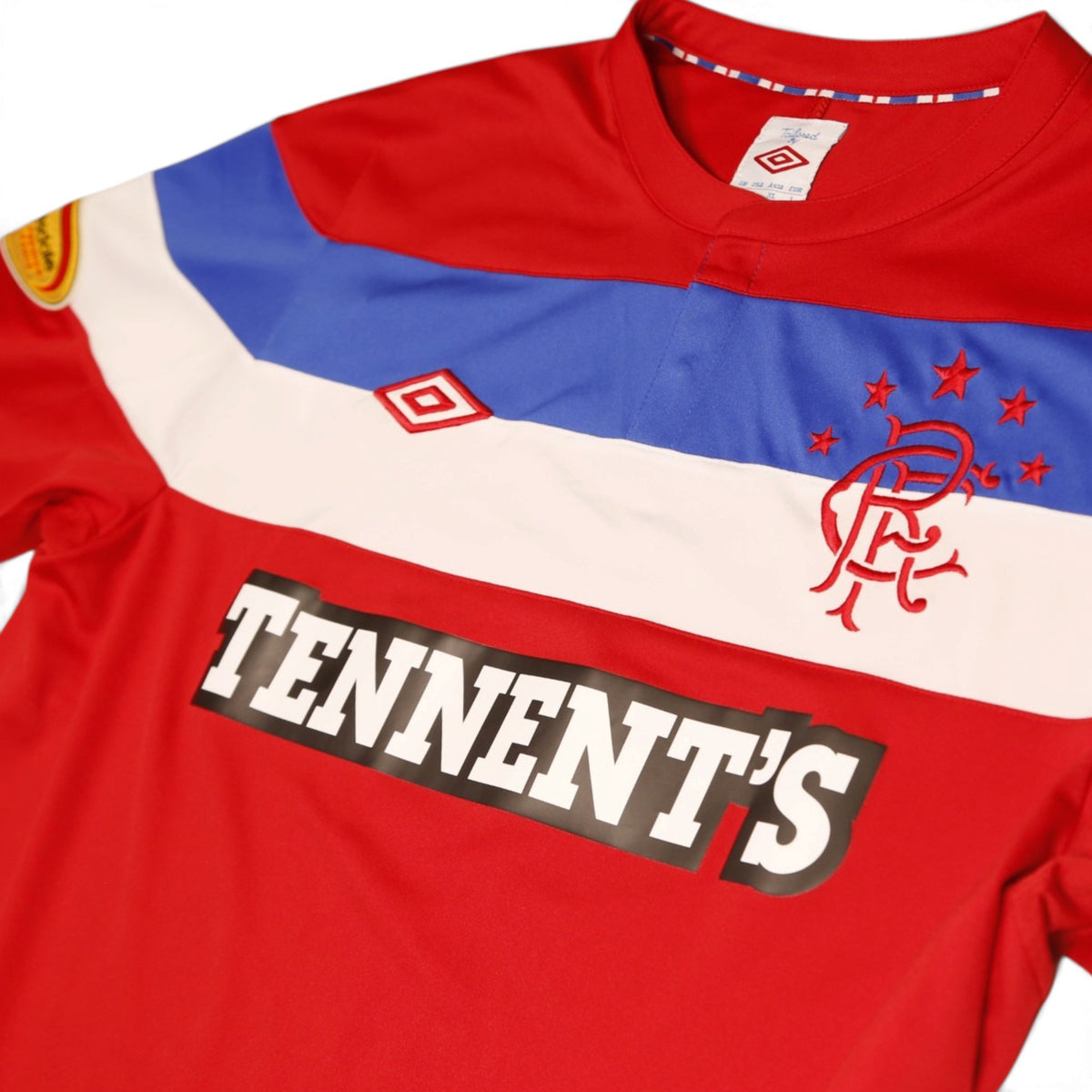 Close-up of Umbro neck label, crest and Tennent's sponsor print