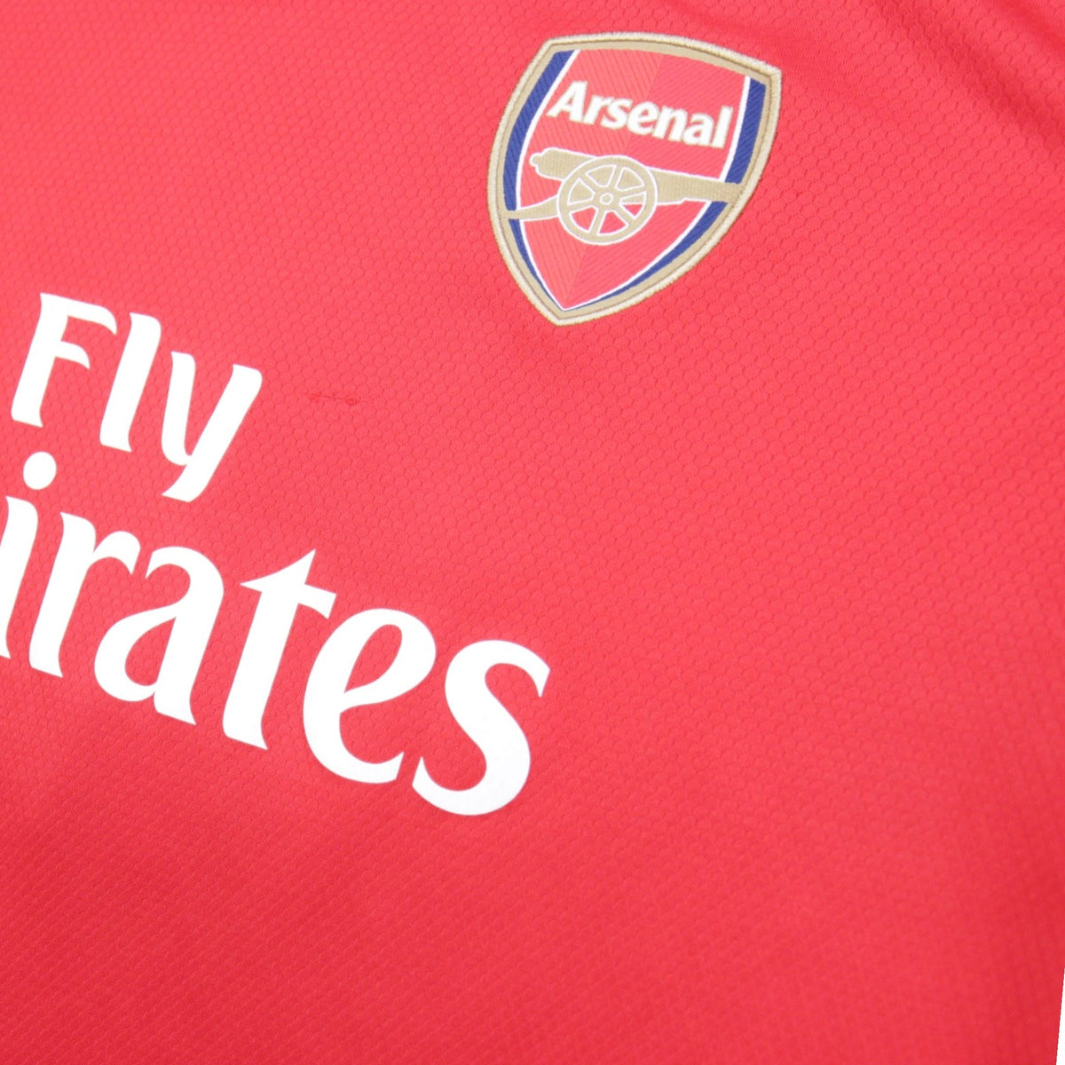 Close-up of Arsenal crest and Fly Emirates sponsor print