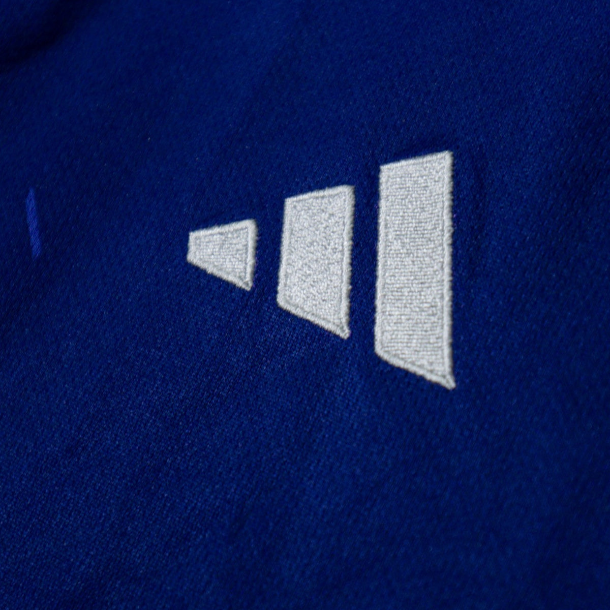 Close-up of the adidas three-stripe logo on the shoulder