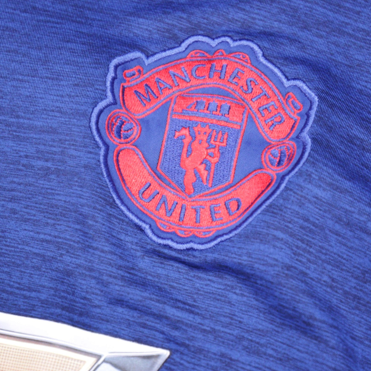 Close-up of Manchester United crest embroidery on shirt