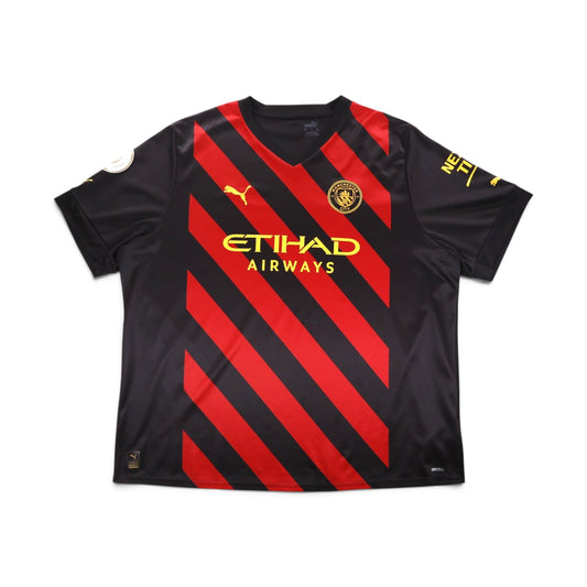 Front of black Manchester City away shirt with red diagonal stripes and Etihad Airways sponsor