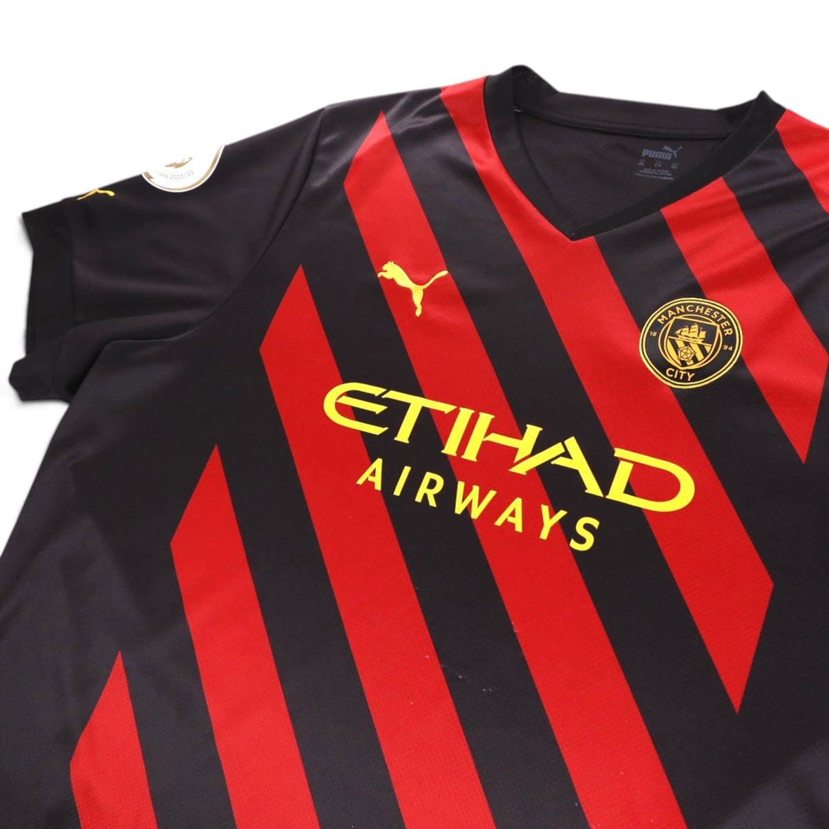 Close-up of Manchester City crest, Etihad Airways sponsor and Puma neck label