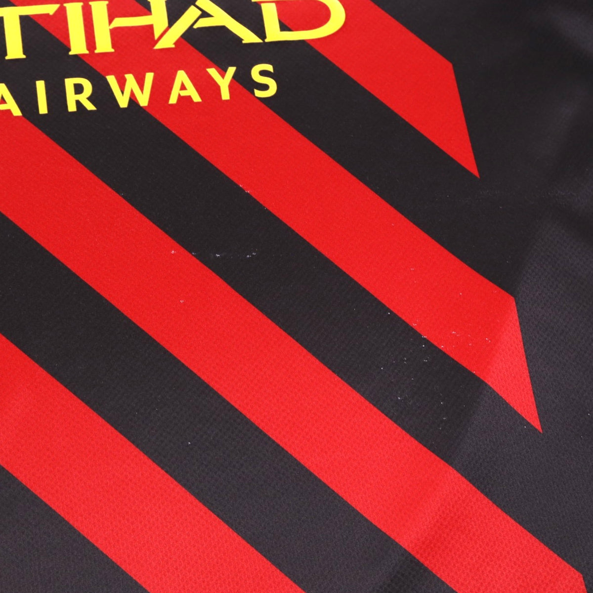 Close-up of the front fabric showing diagonal red stripes and small marks