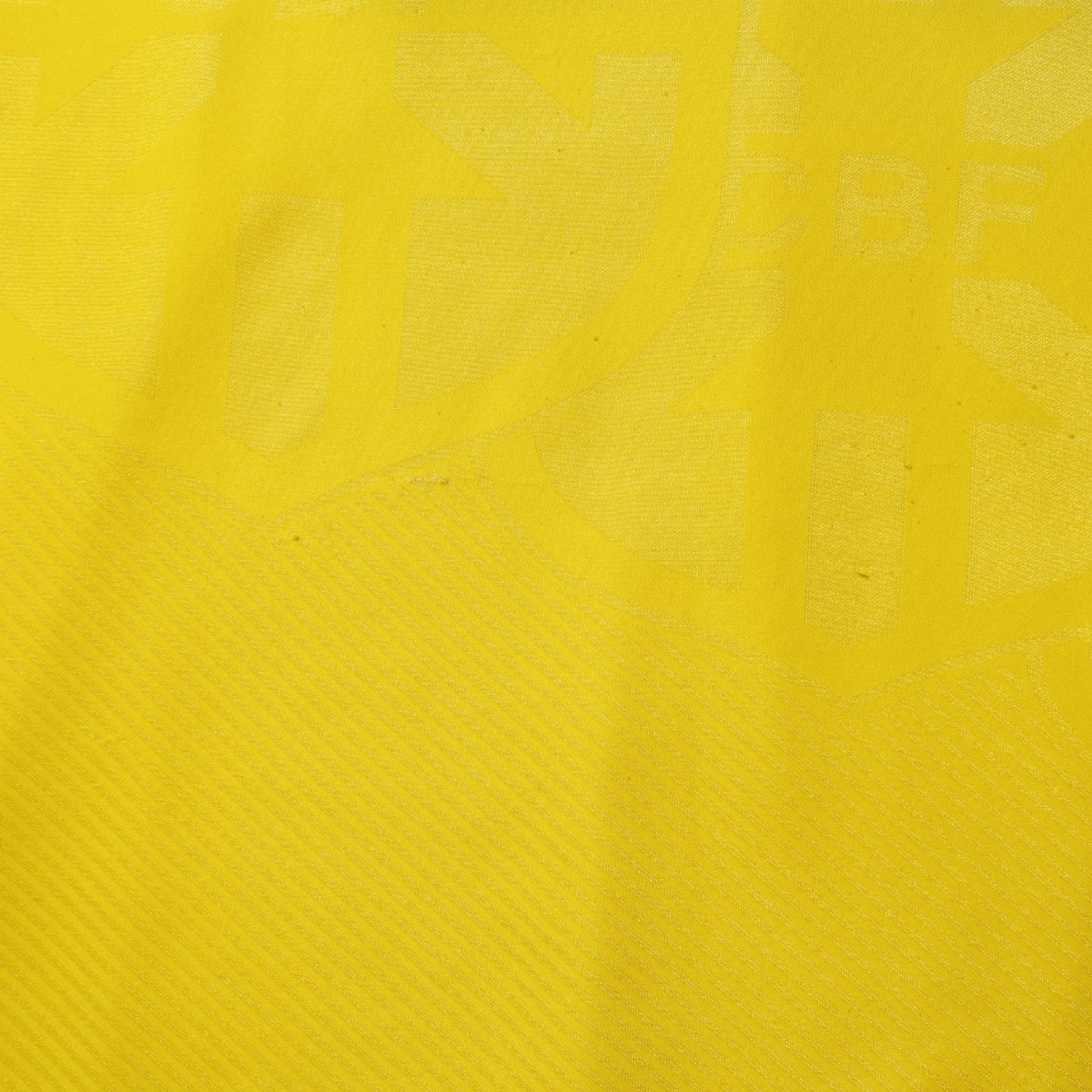 Close-up of yellow jacquard fabric texture on Brazil shirt
