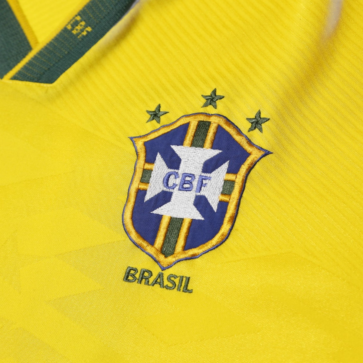 Close-up of CBF Brasil crest with three stars on Brazil shirt
