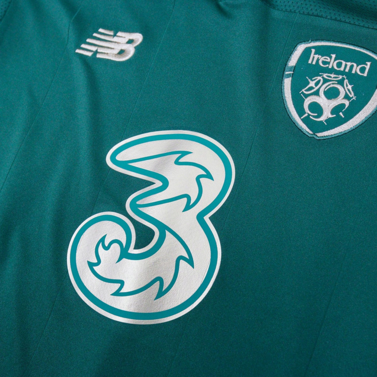 Close-up of the New Balance logo and Ireland crest on the chest of the home shirt