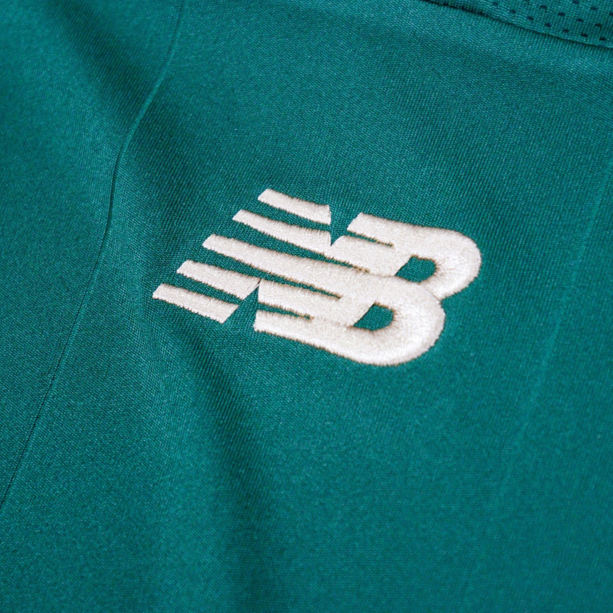 Close-up of the New Balance logo on the chest of the home shirt