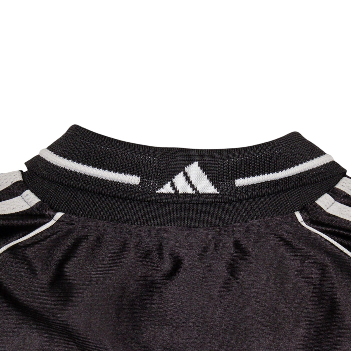 Close-up of V-neck collar with white piping and woven adidas logo
