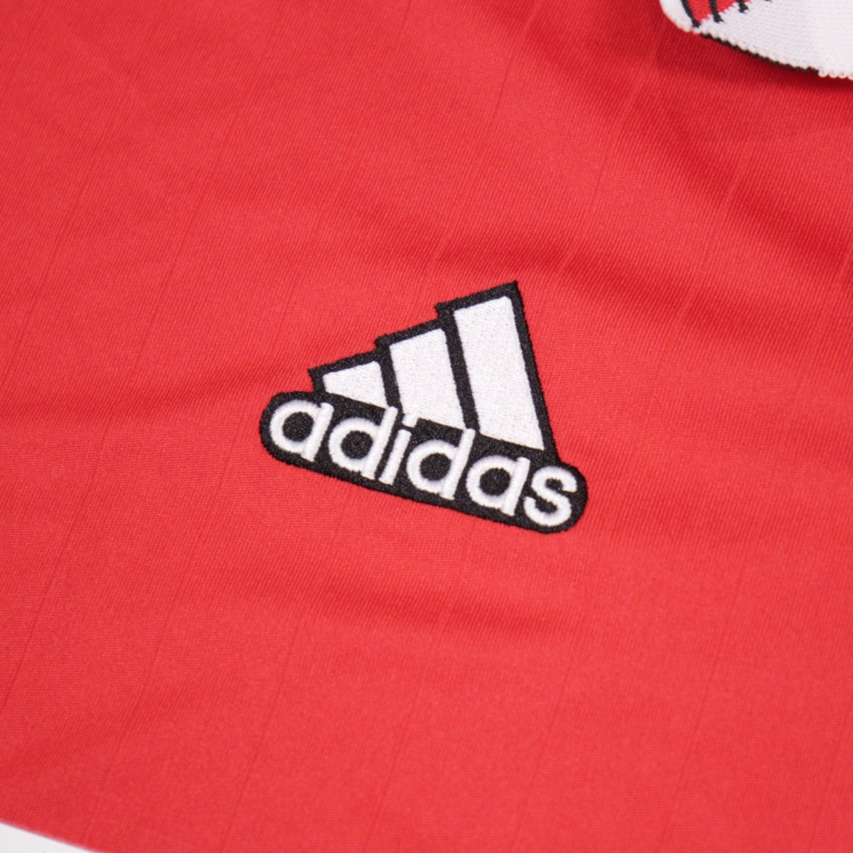 Close-up of the adidas logo embroidered on the shirt