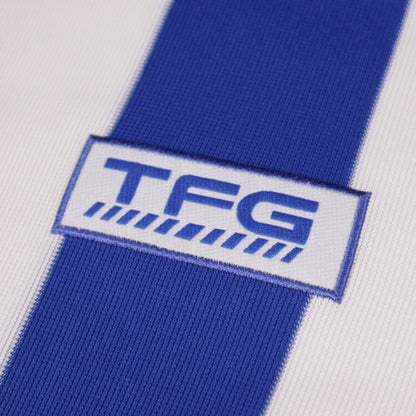 Close-up of TFG manufacturer logo on shirt sleeve