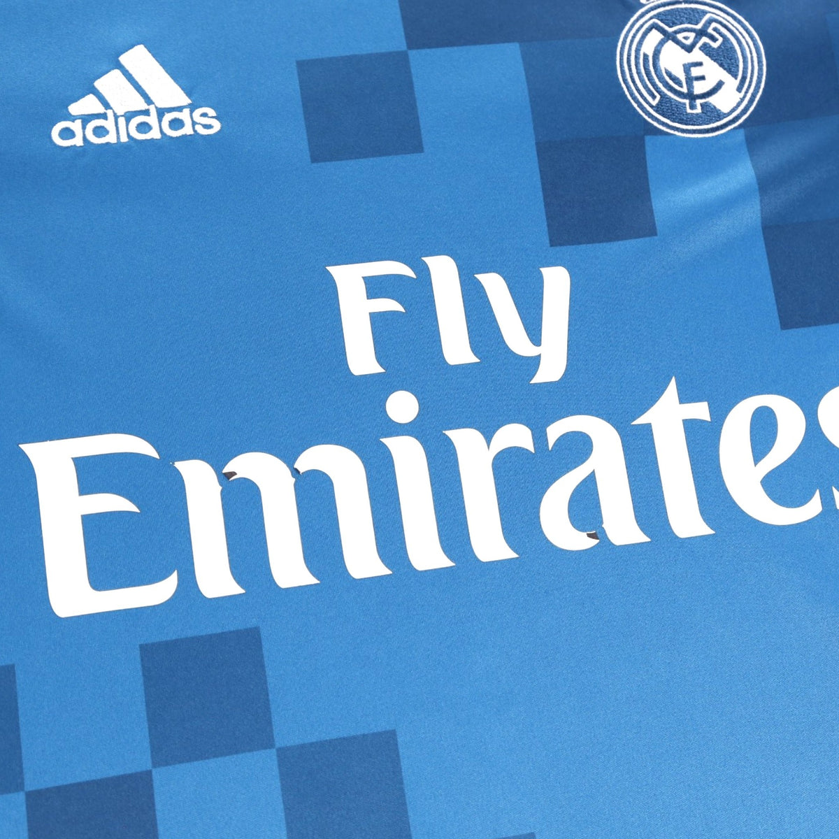 Close-up of the Fly Emirates sponsor and Real Madrid crest on the chest