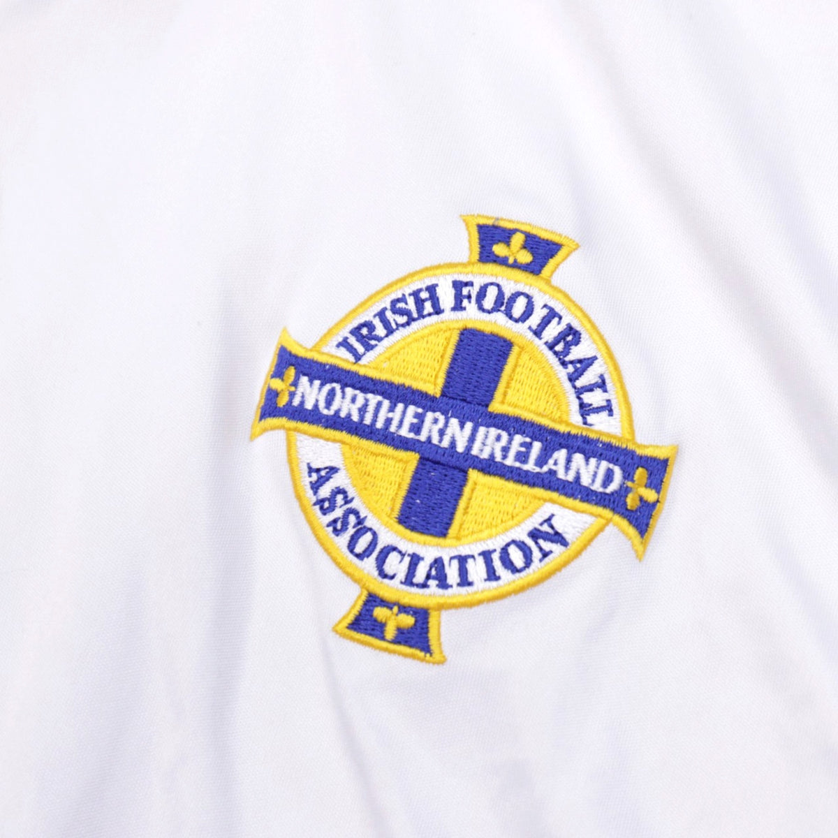 Detail of the embroidered Irish Football Association crest on white shirt fabric