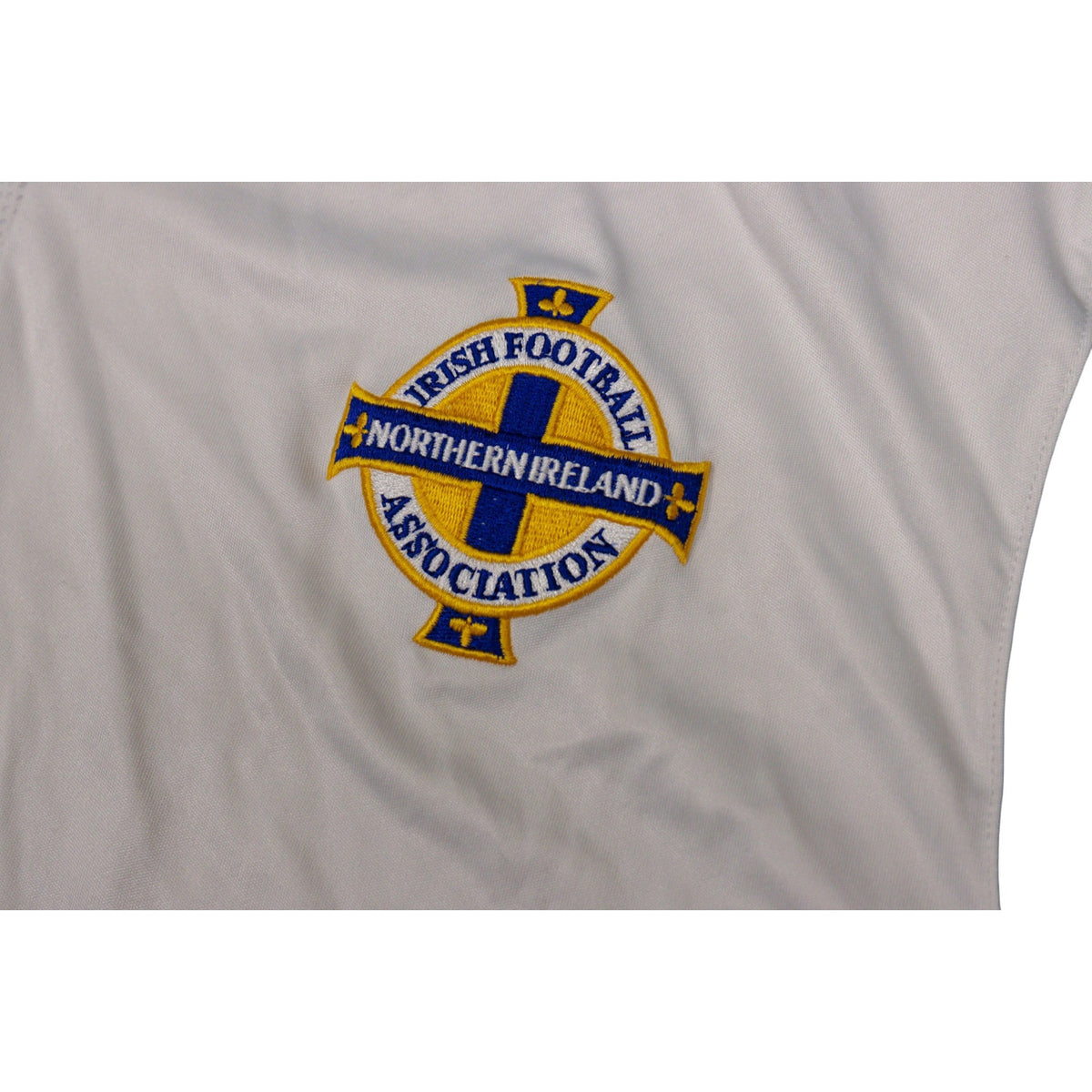 Close-up of embroidered Northern Ireland crest on white shirt fabric