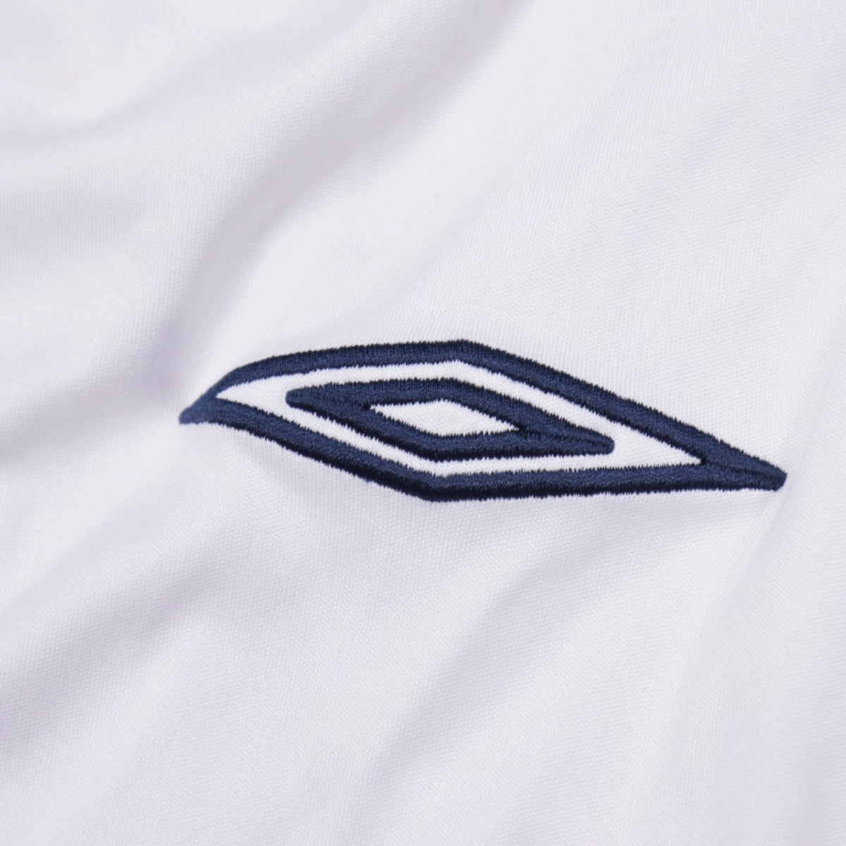Close-up of the Umbro diamond logo on the shirt sleeve