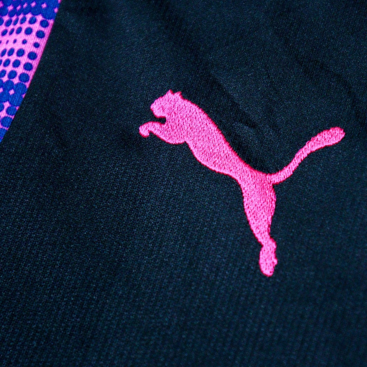 Close-up of the pink Puma logo on the sleeve