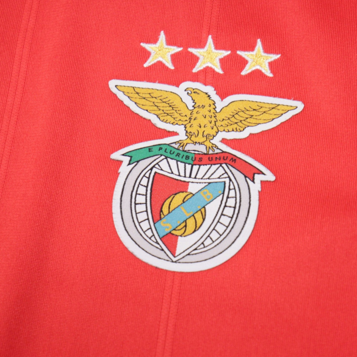Close-up of the Benfica eagle crest and three stars on the shirt