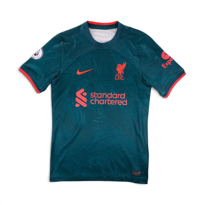 Liverpool 2022/23 third shirt front view, teal-green with coral trim and Standard Chartered sponsor