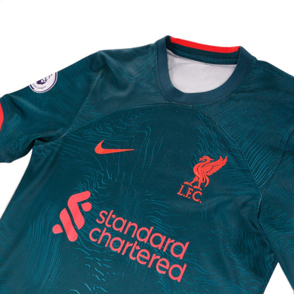 Close-up of the Nike swoosh, Liverpool crest and Standard Chartered sponsor on the chest