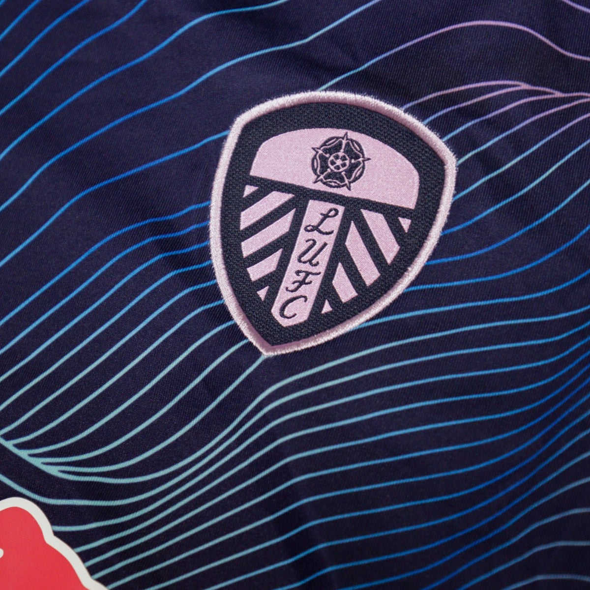 Close-up of Leeds United crest with white rose emblem on the chest