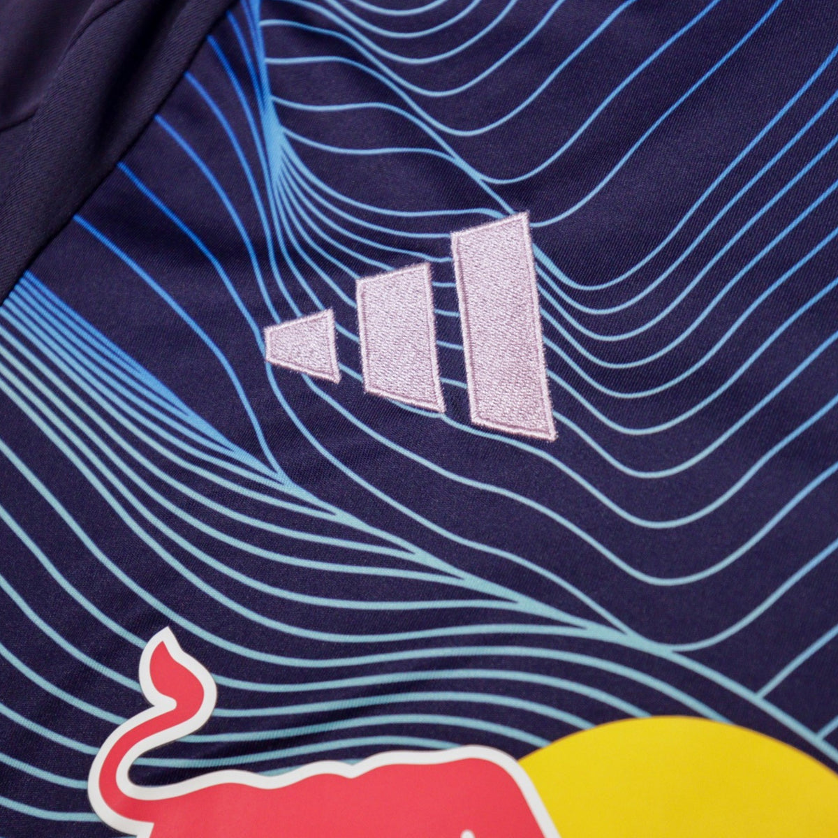 Close-up of adidas logo and blue wave print on the shirt fabric