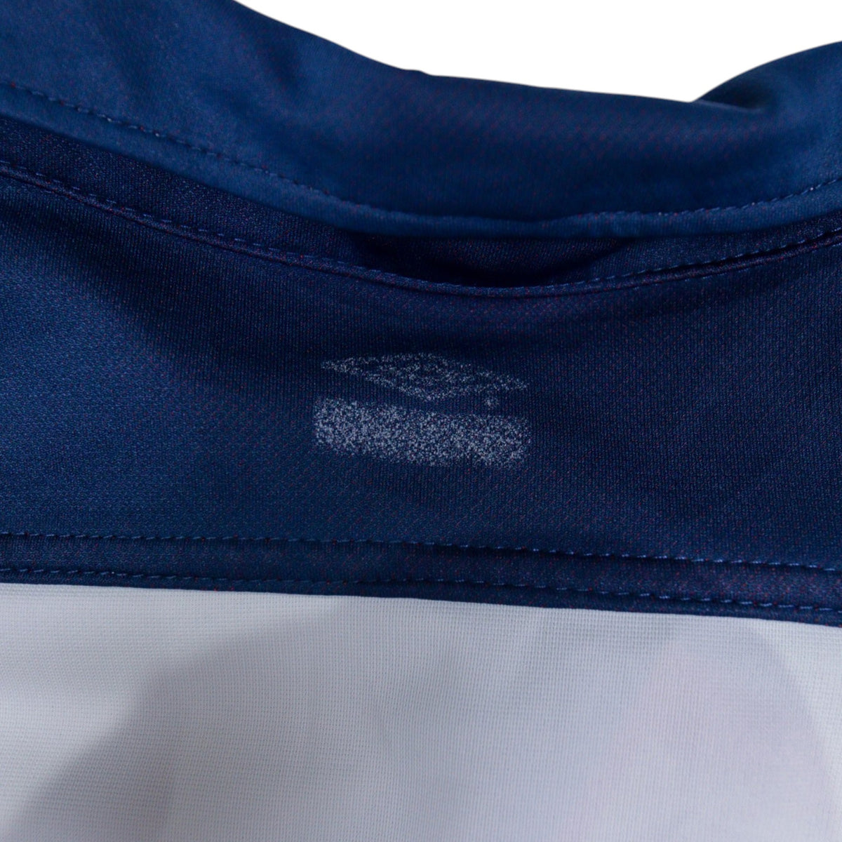 Close-up of faded Umbro logo on the inside neck label