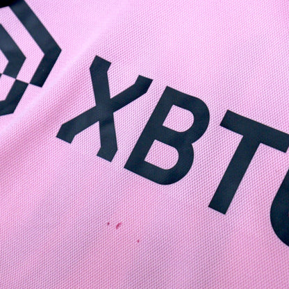 Close-up of the XBTO sponsor print with small marks visible on the fabric