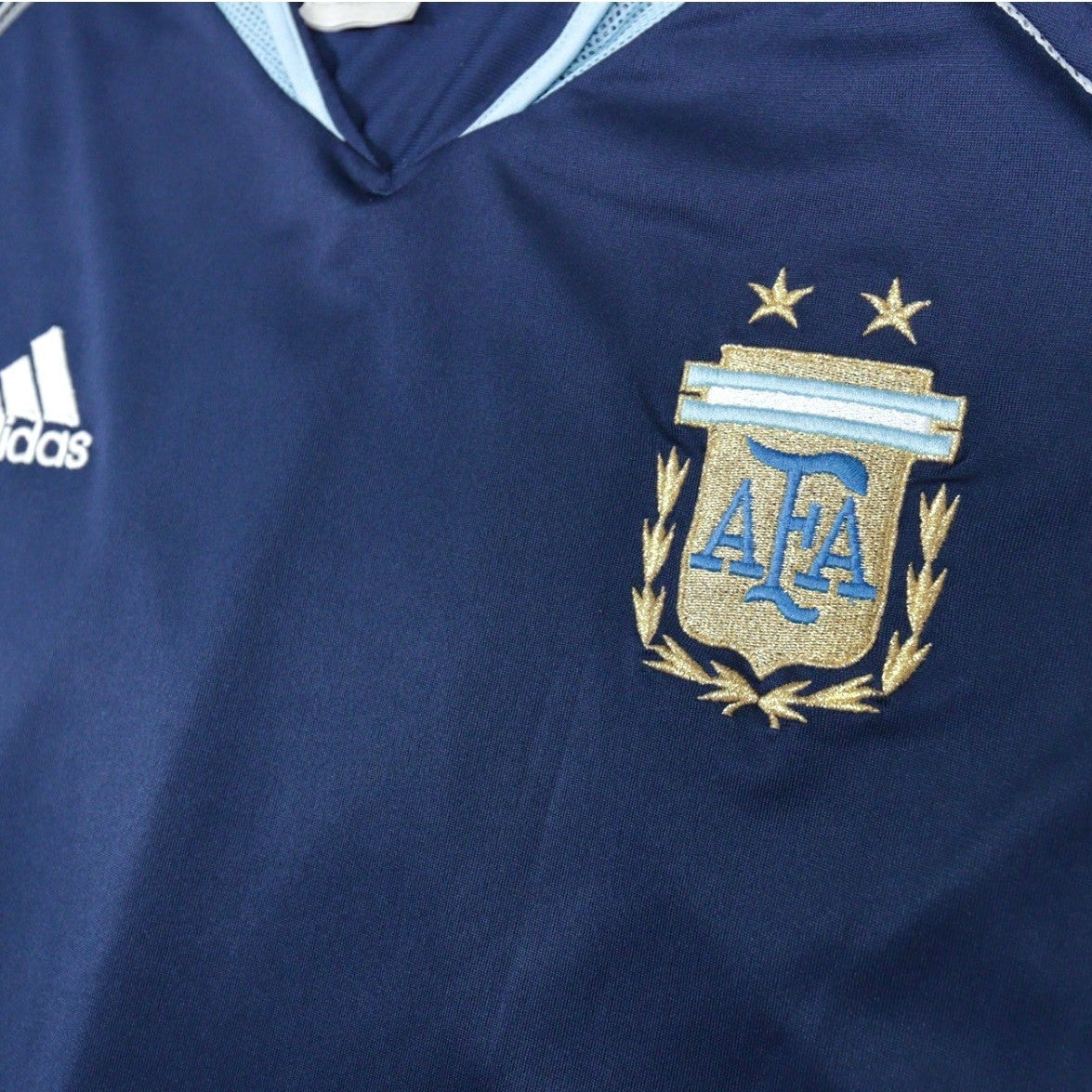Close-up of adidas logo and AFA crest with two stars on the chest