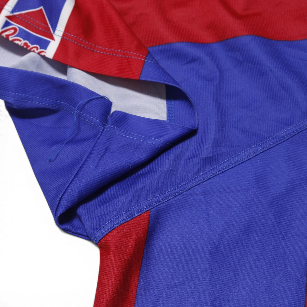 Close-up of underarm seam showing loose thread