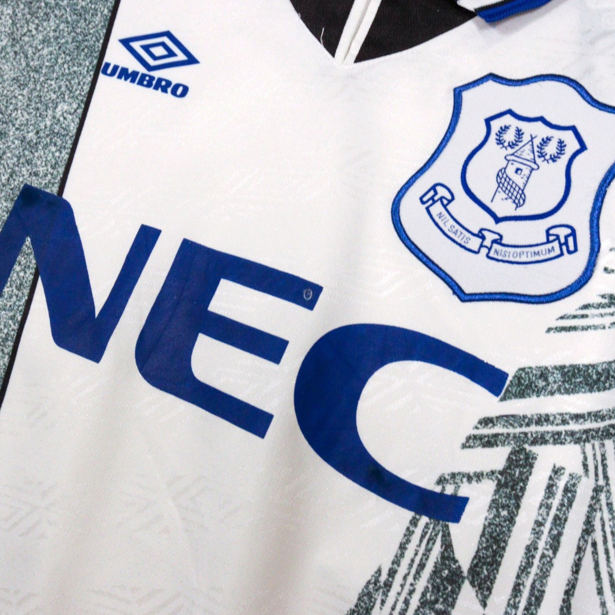 Close-up of Everton crest and NEC sponsor on chest