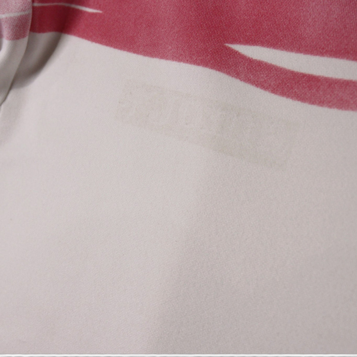 Close-up of a faint mark on the white fabric below the pink stripe